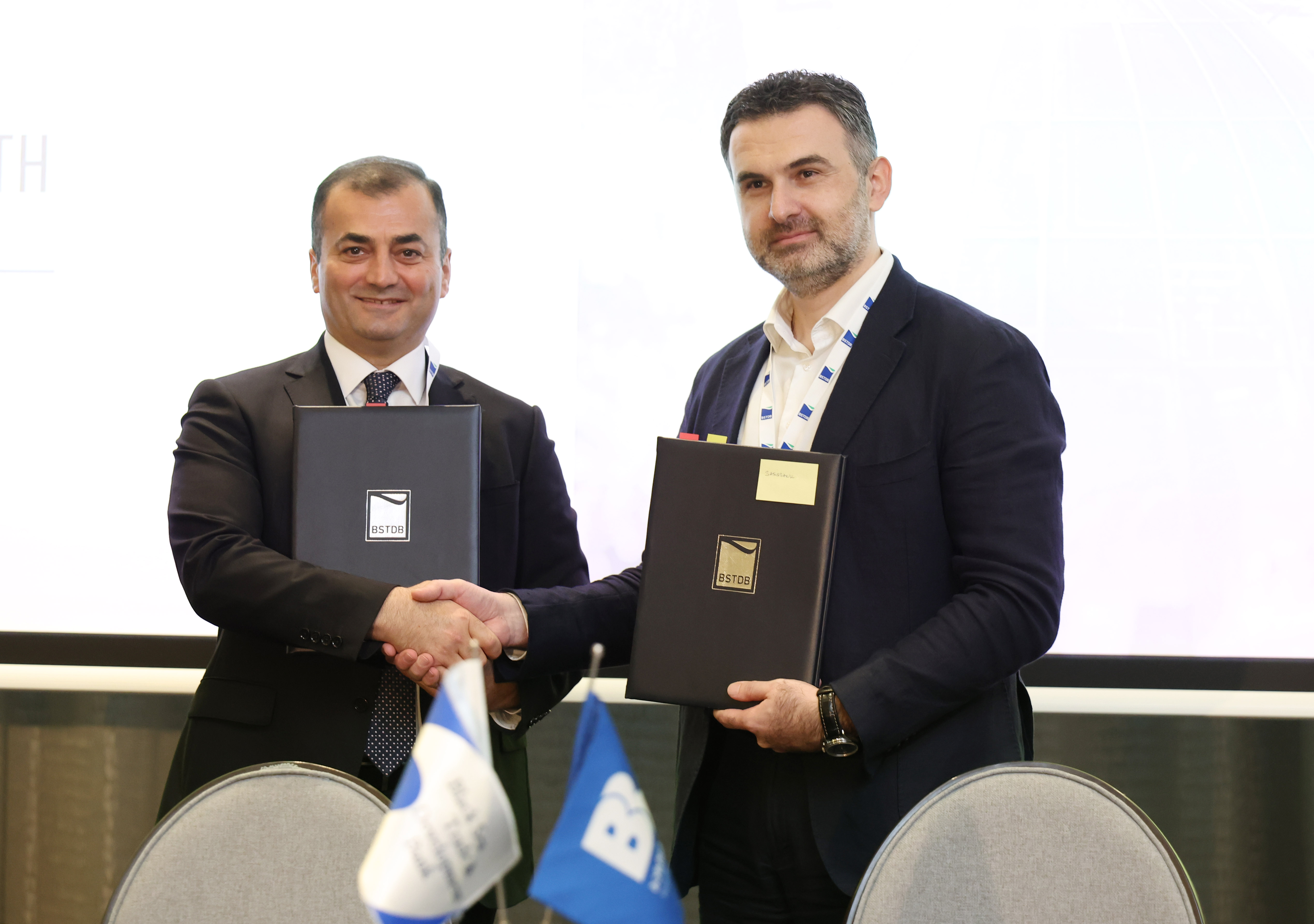 BSTDB Vice President Banking Ziya Aliyev and Basisbank General Director David Tsaava shake hands and hold the signed EUR 25 million SME financing agreement in Tbilisi.