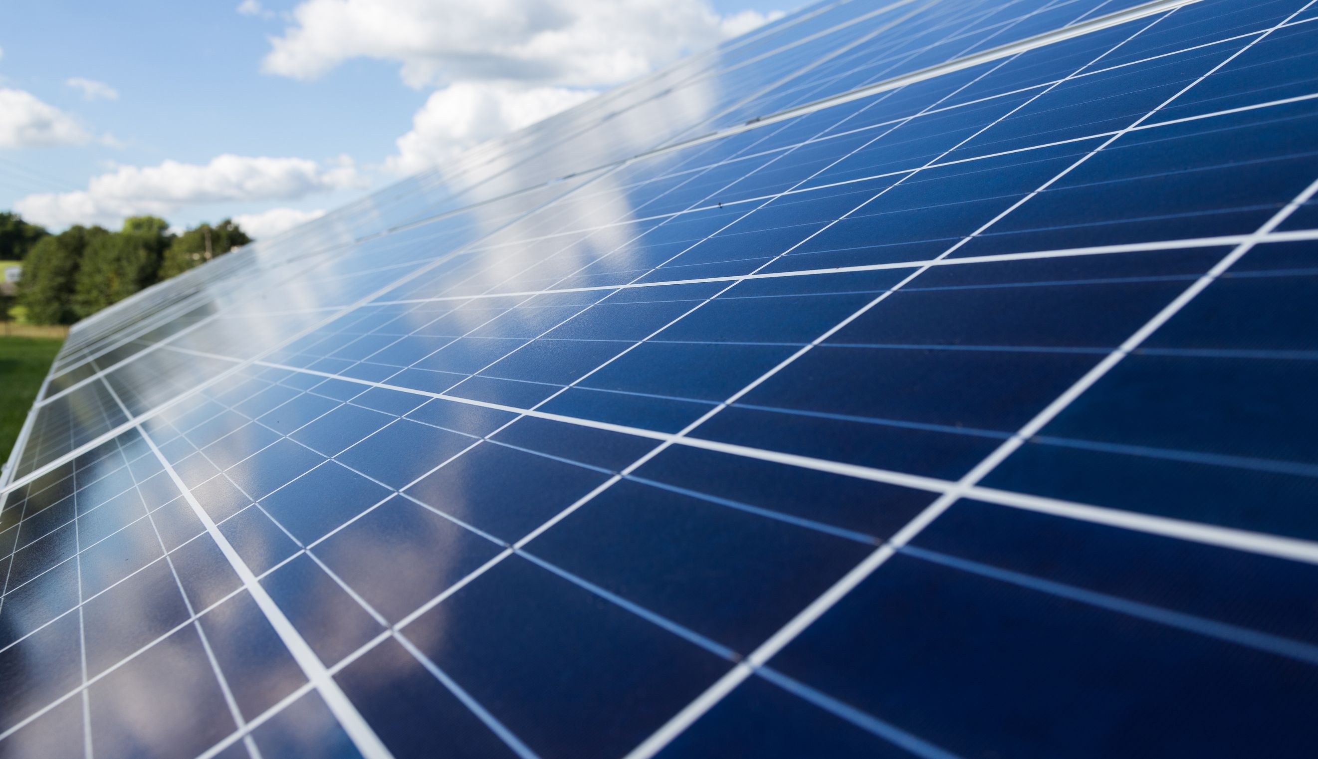 Photovoltaic solar panels under a blue sky, illustrating renewable energy generation.